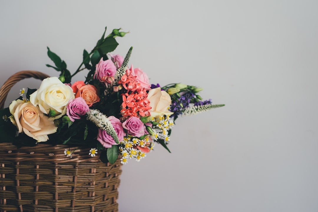 Mixed seasonal flowers in a woven basket