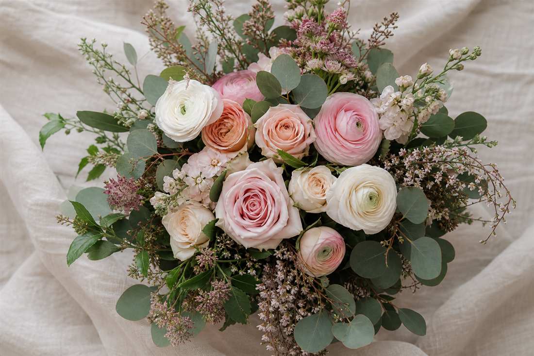 Blush rose and eucalyptus bouquet on linen